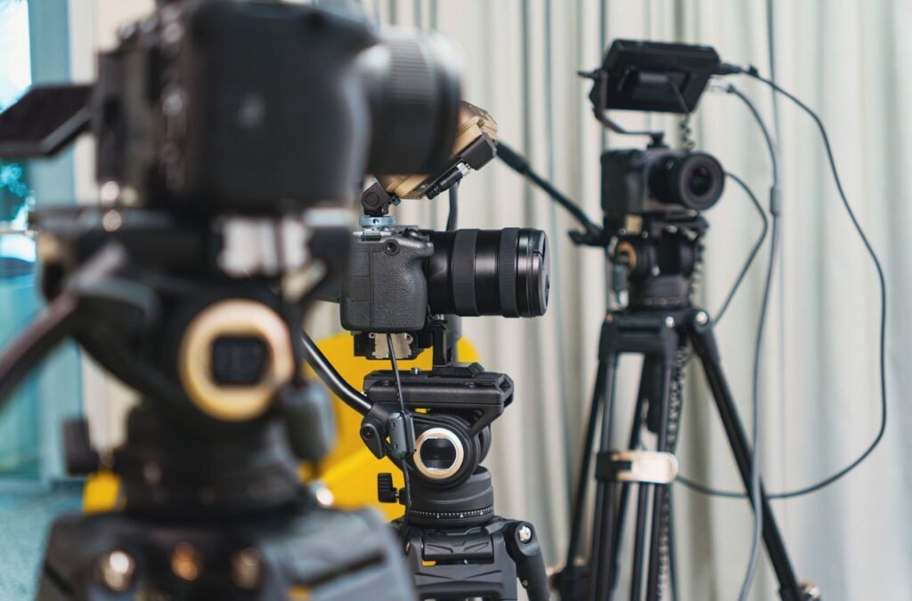 Close-up of high-end video cameras and tripods in a modern studio setting.