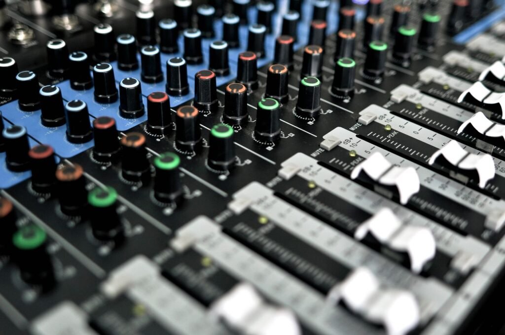 Detailed view of a professional audio mixing console with knobs and sliders for sound control.