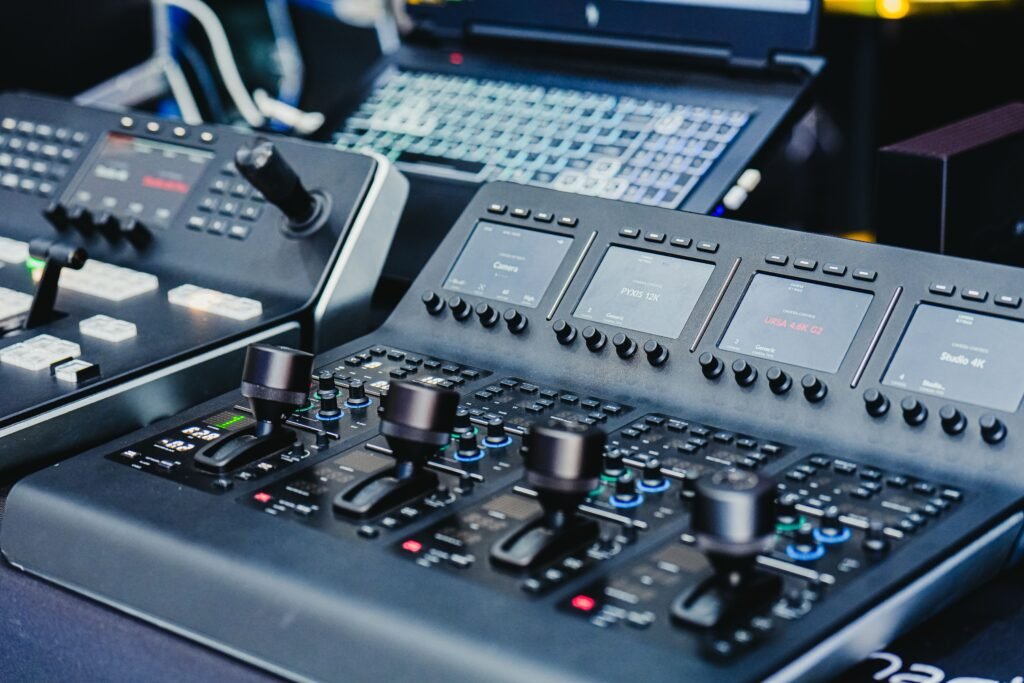 Close-up of a high-tech video editing console with control knobs and screens.